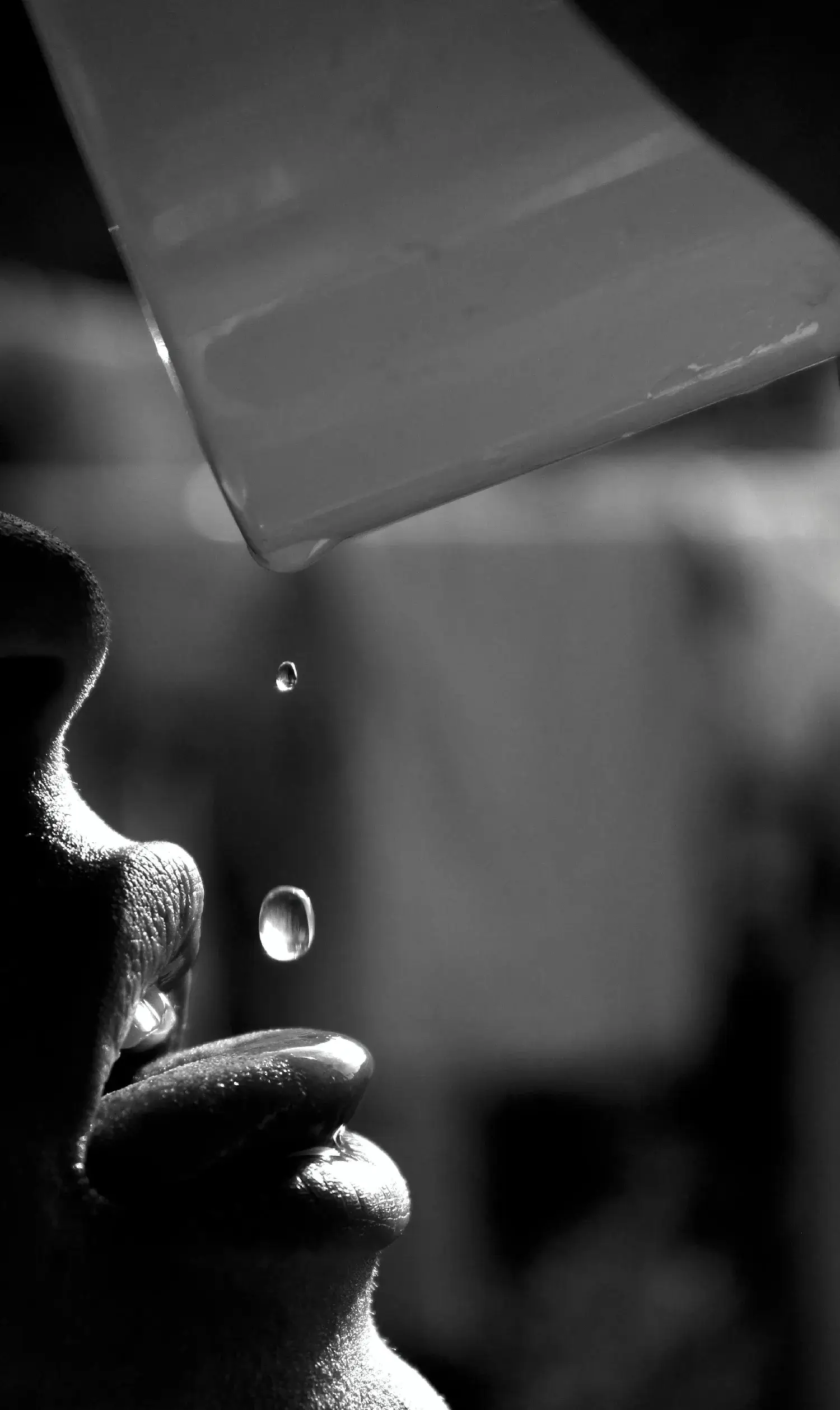 Moody dramatic close up conceptual art frame of water liquid splashes on human skin surface.