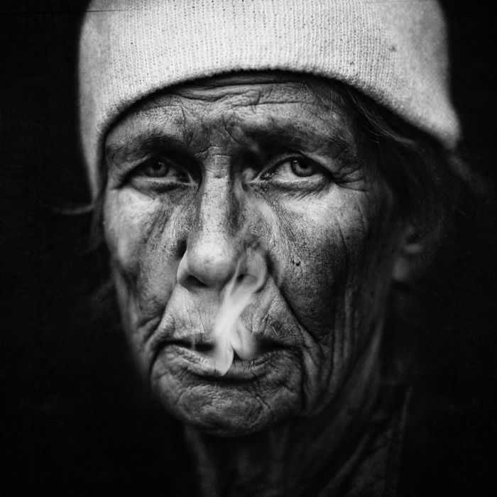 Monochrome studio portrait of a homeless man wearing a knit cap looking off-camera in high contrast